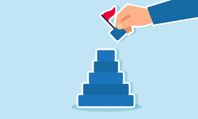 A businessman  hand holding the final puzzle piece of wooden blocks with a flag to complete the puzzle, illustration of A businessman trying to complete or finalize his business project