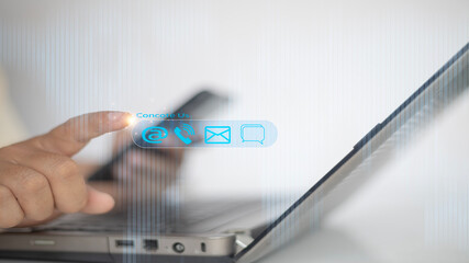 Contact us or Customer support hotline people connect. Businessman using a laptop with virtual screen contact icons