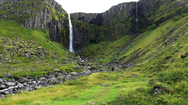 Hicker climbing towards a massive beautiful waterfall