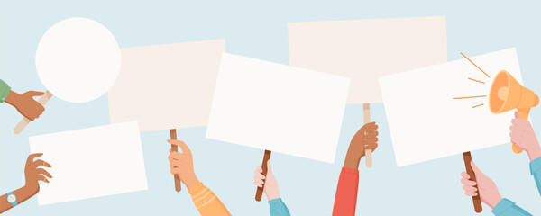 Fototapeta premium Protest signs are held high by a diverse hands. People raise placards and banners with a strong message. Human hand lift blank boards, showing unity, solidarity and support in the demonstration.