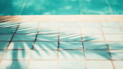 Obraz premium Palm leaf shadows create a striking pattern on vibrant tiles near a refreshing swimming pool under clear blue skies