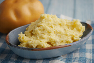 Delicious Creamy Mashed Potatoes Presented in a Serving Dish Alongside Fresh Potatoes