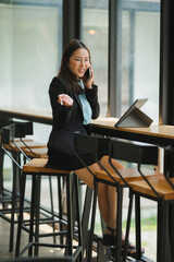 Businesswoman on Phone Call: A young, confident businesswoman in a stylish business suit, engrossed...