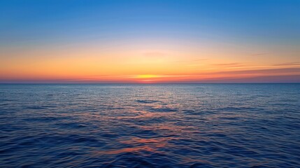 Obraz premium A serene ocean view at sunset, showcasing vibrant colors reflecting on the water's surface.