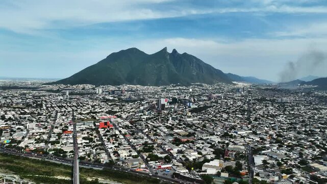 Panoramic drone shot of the Monterrey city and the Cerro de la silla mountain