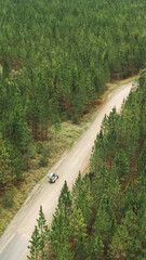 drone image of a land rover driving through a forest
