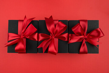 Top view photo of gift boxes with bow on isolated red background.
