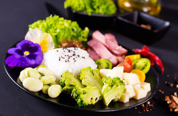 Rice and broccoli served on a plate on dark background