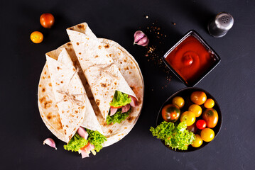 wrap sandwich with ham, lettuce, tomatoes and cheeses