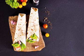 wrap sandwich with ham, lettuce, tomatoes and cheeses