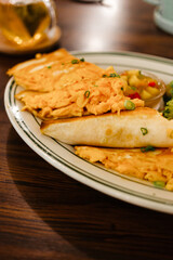 Omelet with cheese and onions in a fried tortilla. Concept of vegetable tacos on a plate