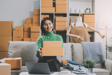 Asian SME business women use laptop computer checking customer order online shipping boxes at home....