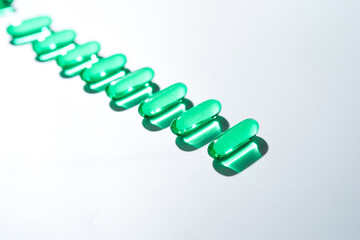 Vitamin E softgel capsules, vitamin D3, fish oil, omega 3, Green oil pills on a white background