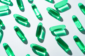 Vitamin E softgel capsules, vitamin D3, fish oil, omega 3, Green oil pills on a white background