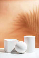 White geometric shapes arranged stylishly on a soft peach background in a minimalist setting