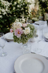 A bouquet of flowers on the table. Outdoor table setting. Lunch in the garden.