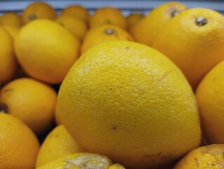 Close-up of a Single Ripe Yellow Citrus Fruit Among Others