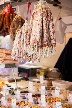 Salami hanging at a shop for sale.