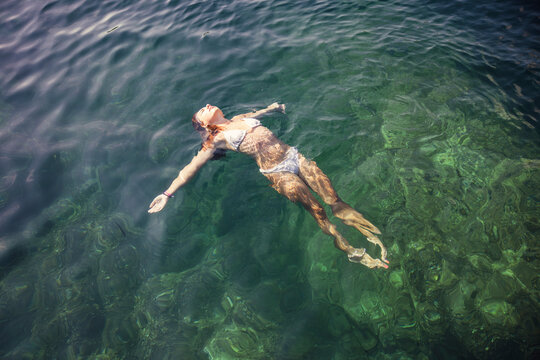 Young girl playing and swimming in the Mediterranean Sea. Spain