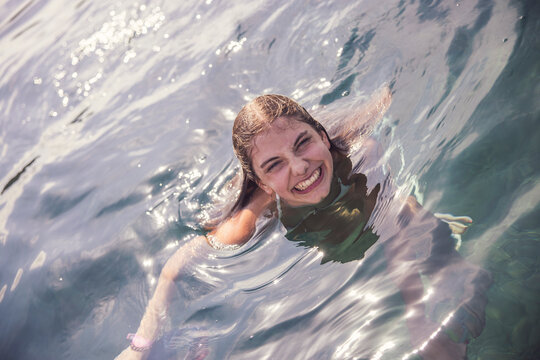 Young girl playing and swimming in the Mediterranean Sea. Spain