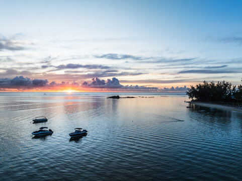 Aerial view of sunset over the ocean with sailboat. Grand Baie, Mauritius
