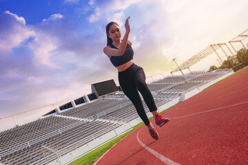 Fit young woman running sprinting at the racetrack. Fit runner fitness runner during outdoor...