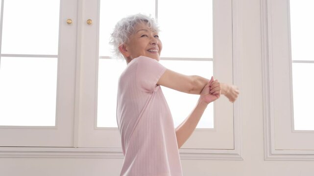 腕をストレッチする高齢者の女性