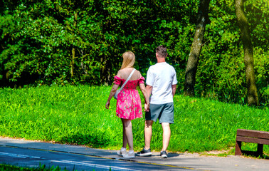 Obraz premium A man and a woman walk in a summer park 