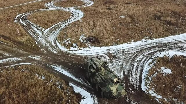 Military equipment at the training ground. Bucephalus armored personnel carrier of Ukrainian army riding on the road. Top view from a drone. Aerial reconnaissance