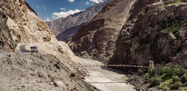 A typical Pakistan bridge is built over a rocky mountain