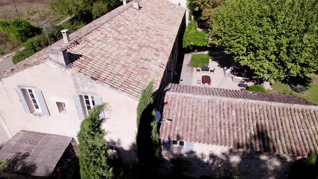 Aerial orbiting shot overhead a villa with garden seating in Goult, france