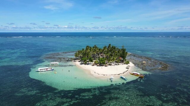 Aerial drone shot of Guyam Island in Siargao, Philippines, showcasing a pristine white sand beach, clear turquoise waters, and lush tropical scenery, Perfect for nature or travel themed projects.