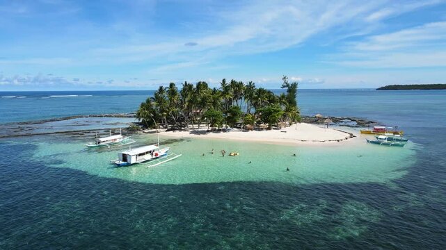 Aerial drone shot of Guyam Island in Siargao, Philippines, showcasing a pristine white sand beach, clear turquoise waters, and lush tropical scenery, Perfect for nature or travel themed projects.
