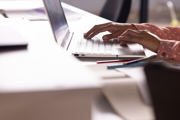 At office, Typing on laptop, woman working on creative writing project at desk