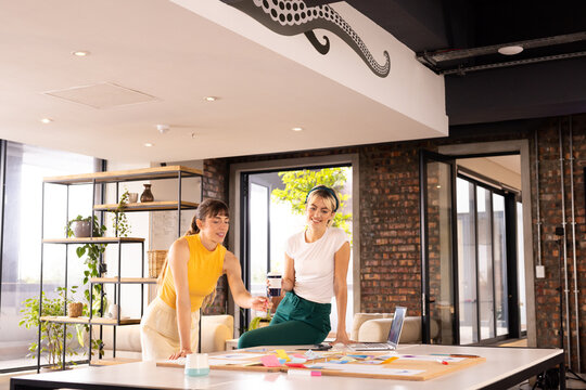 Collaborating on project, two women brainstorming ideas with sticky notes in office