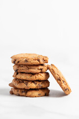 stacked chocolate chip cookies on white background