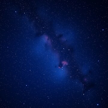A dark blue night sky filled with stars, a faint glow of pink in the Milky Way.