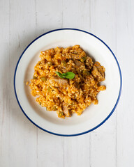 Rice paella with pork loin and green beans. Top view table.