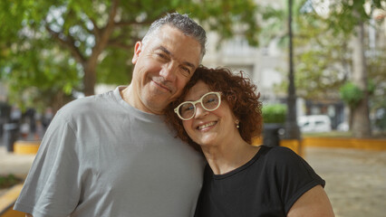 Middle-aged couple smiling together in an outdoor urban park