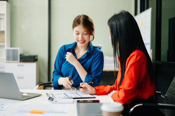 Asian business colleague business presents and explains and using laptop and tablet. Teamwork, financial