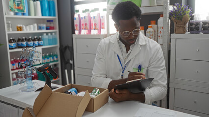 Man working in a pharmacy checks inventory inside a drugstore with shelves full of products and a barcode scanner on the counter.