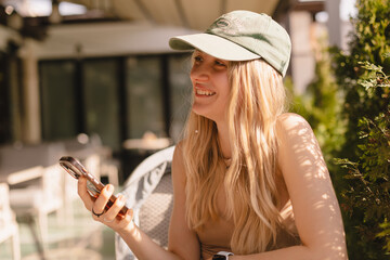 Attractive blonde woman sitting in cafe, laughing and look at side. Girl have a good time in cafe...