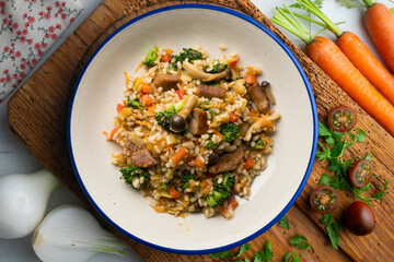 Rice paella with pork loin, mushrooms and broccoli. Top view table.