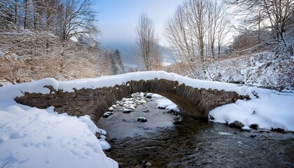 Snow-covered stone bridge over a small stream.