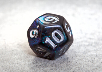 twelve-sided dice with blue shimmer showing number 10. 
Gaming and role-playing dice, selective...