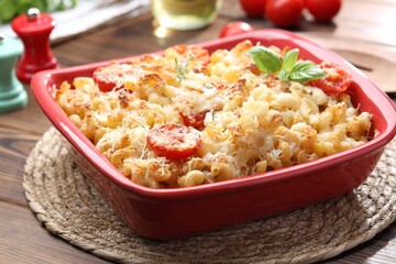 Delicious al forno pasta in baking dish on wooden table, closeup