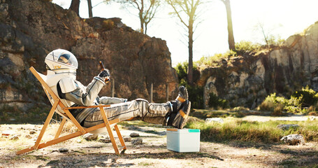 Relax, nature and astronaut with beer on camping trip for vacation, holiday or getaway in Norway. Person, cooler box and space pilot with drink and resting outdoor in woods for weekend chill on break © HockleyM3/peopleimages.com