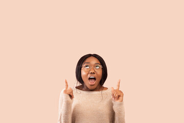Look Up. Positive Black Woman Pointing Fingers Upward Standing Over Pink Studio Background. Panorama