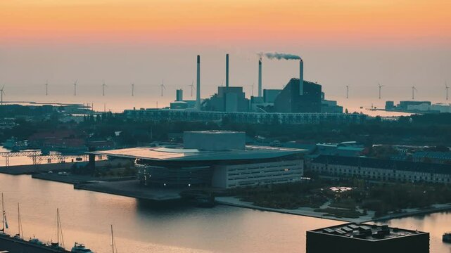 Aerial approaching Copenhill Energy Plant and Opera House at sunrise in Copenhagen, Denmark.