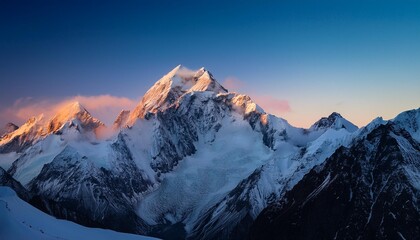 Obraz premium Snow-covered mountain peaks at dawn